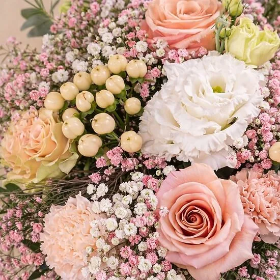 Close-up of pink roses, peach carnations and white lisianthus in powdery tones