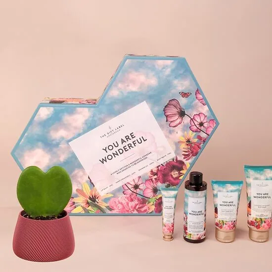 Coffret bien-être fleuri: heart-shaped gift box with four body-care products and a Hoya kerrii plant
