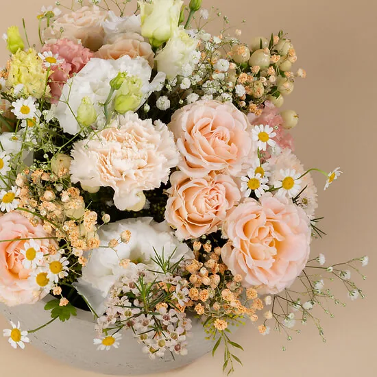 Close-up of peach roses, white carnations and gypsophila in the Douceur arrangement