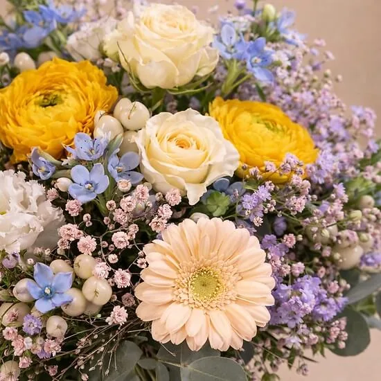 Top view of the Petit cœur bouquet with white roses, yellow ranunculus and blue tweedia